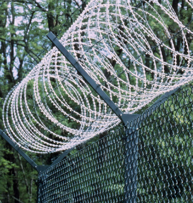 Perimeter fence of barbed wire topped chain link fence